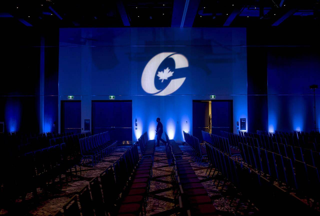 A man is silhouetted walking past a Conservative Party logo before the opening of the party’s national convention in Halifax on Thursday, August 23, 2018. The Conservative party’s first openly trans candidate says she wasn’t surprised delegate voted against gender-affirming care but warns of harm “the transphobic language” could cause if it becomes a law. THE CANADIAN PRESS/Darren Calabrese
