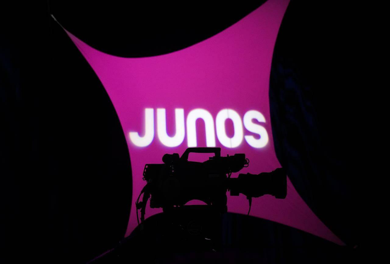 The Juno Awards have introduced new “AI Eligibility” submission guidelines for music creators to specify how much artificial intelligence technology can be used in recordings. A video camera is silhouetted as people gather for a press conference for the 2023 Juno Award nominee announcement in Toronto, on Tuesday, January 31, 2023. THE CANADIAN PRESS/Nathan Denette