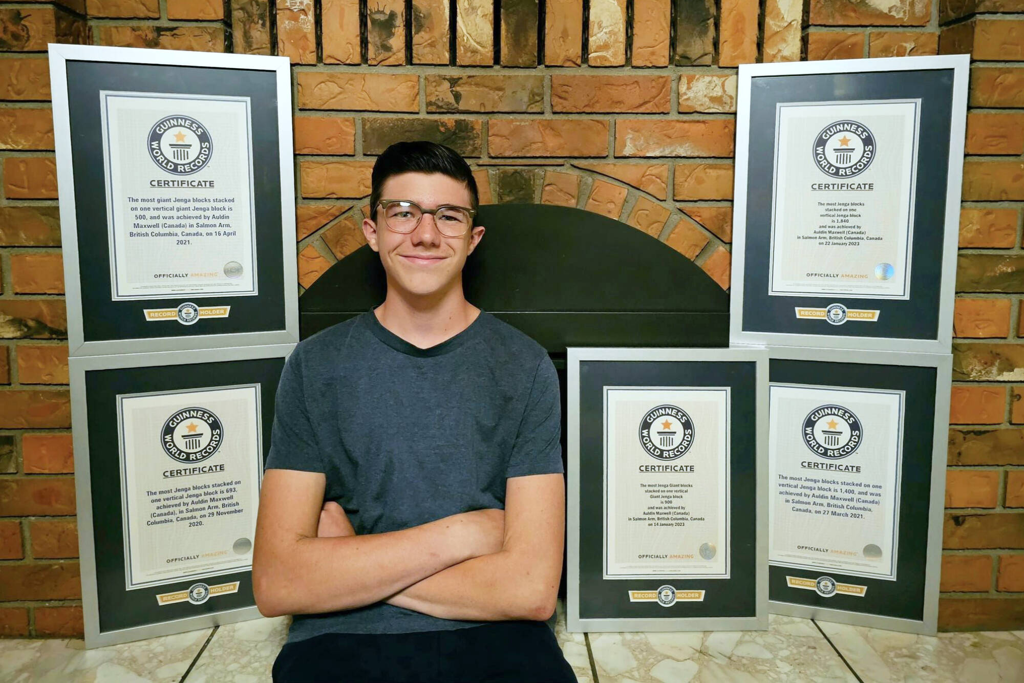 Salmon Arm’s Auldin Maxwell sits with the five Guinness World Records certificates he received for his record-breaking Jenga block towers. (Kelly Murray photo)