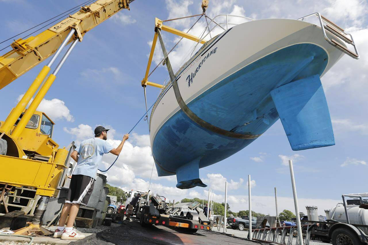 Davis & Tripp Marina and Boat Yard crews pull a sailboat named Hurricane from the waters of Padanaram Harbor in Dartmouth, Mass., Thursday, Sept. 14, 2023 in preparation for the possible arrival of Hurricane Lee. (Peter Pereira/The Standard-Times via AP)