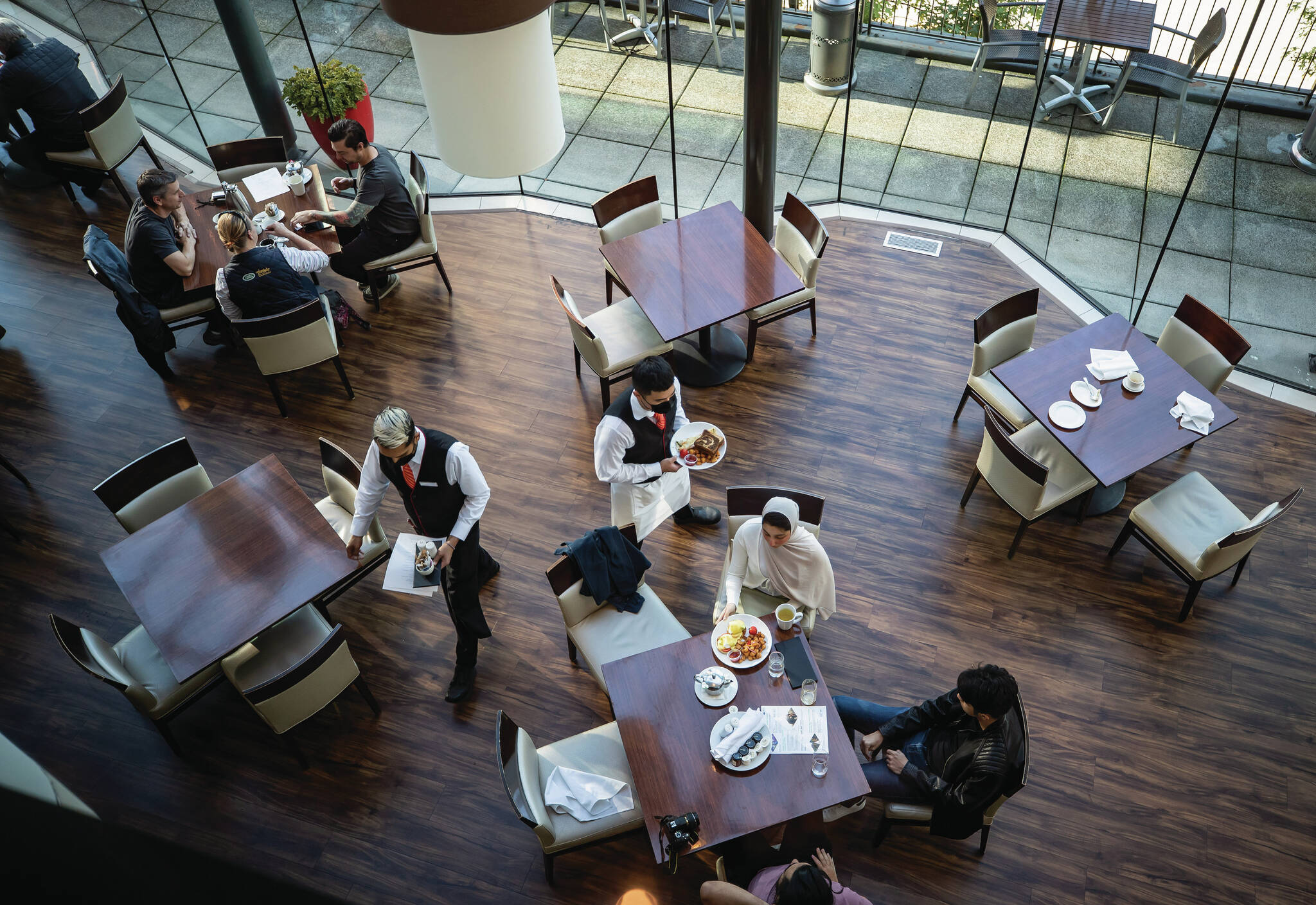 A server brings food to a table as people dine at a restaurant in Vancouver, on Tuesday, September 21, 2021. The federal government’s extension for a small business loan repayment plan was touted as a win for businesses, but has instead drawn mixed reactions from industry experts with one saying it’s left owners on “pins and needles.” THE CANADIAN PRESS/Darryl Dyck