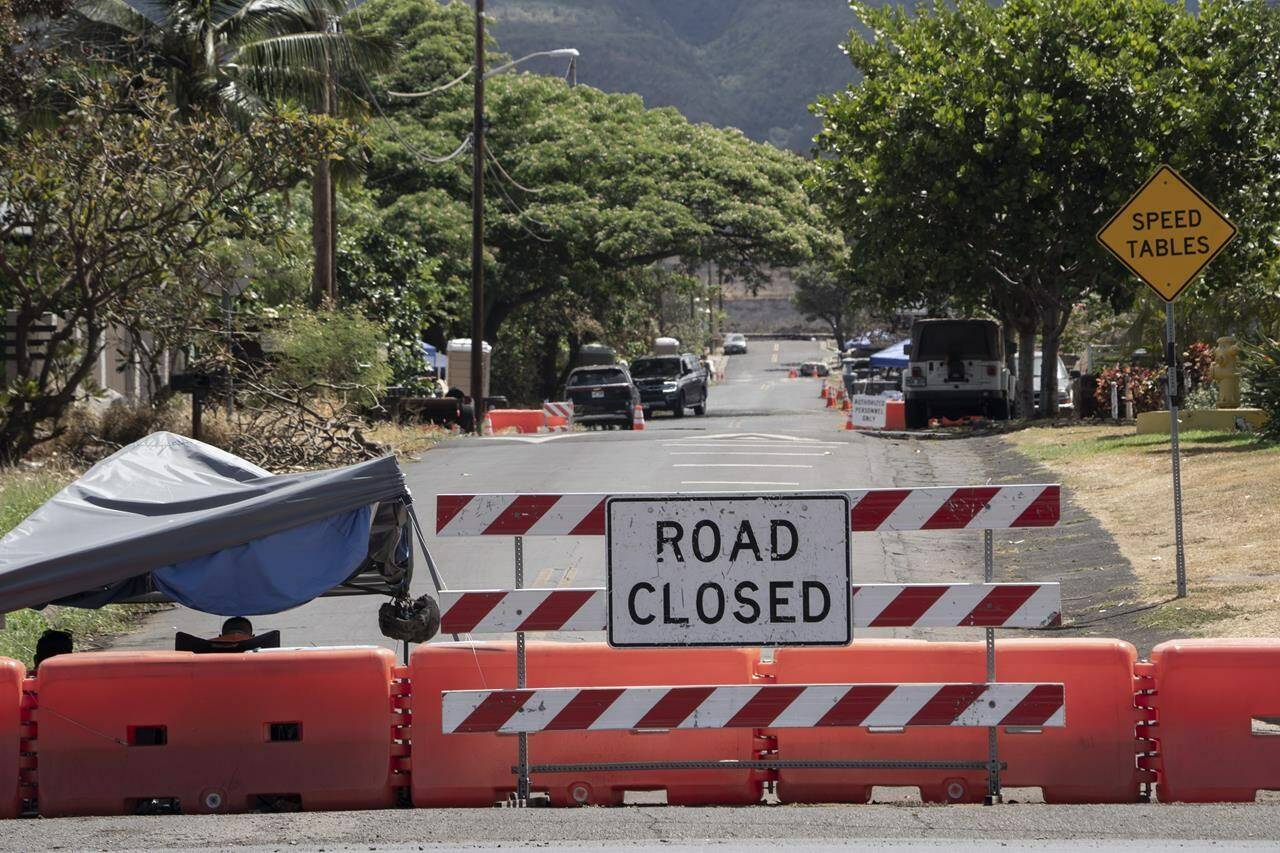 A checkpoint set up by the Hawaii National Guard is pictured on Kaniau Road, Sunday, Sept. 24, 2023, in Lahaina, Hawaii. Kaniau Road of Zone 1C will be the first zone to be cleared for residents to reenter, starting Monday, Sep. 25, following Maui’s deadly wildfire. (AP Photo/Mengshin Lin)