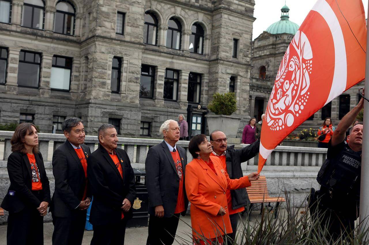 BC Green party Leader Sonia Furstenau, (left to right) BC United MLA Michael Lee, Grand Chief Stewart Phillip, Minister of Indigenous Relations and Reconciliation Murray Rankin, MLA Joan Phillips and MLA Raj Chouhan raise the Survivors’ Flag to honour the hundreds of children who never returned home from residential schools, during a ceremony at the legislature in Victoria, B.C., on Monday, Sept. 25, 2023. THE CANADIAN PRESS/Chad Hipolito