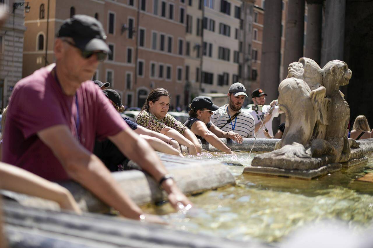 FILE - People cool off at a fountain in front of the Pantheon, in Rome, Saturday, Aug. 19, 2023, where temperatures were expected to reach as high as 37 Celsius (98 Farenheit). This was the hottest summer on record across the globe, forcing many tourists to rethink how and where they travel. (AP Photo/Andrew Medichini, FIle)