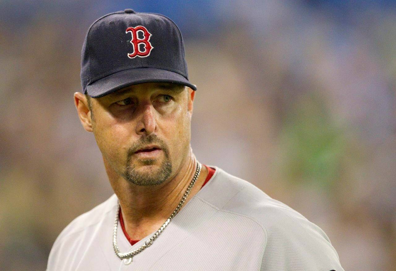 FILE - Boston Red Sox starting pitcher Tim Wakefield leaves the field after working against the Toronto Blue Jays in a Sept. 7, 2011 baseball game in Toronto. Wakefield, the knuckleballing workhorse of the Red Sox pitching staff who bounced back after giving up a season-ending home run to the Yankees in the 2003 playoffs to help Boston win its curse-busting World Series title the following year, has died. He was 57. The Red Sox announced his death in a statement Sunday, Oct. 1 2023, (Darren Calabrese/Canadian Press via AP, file)