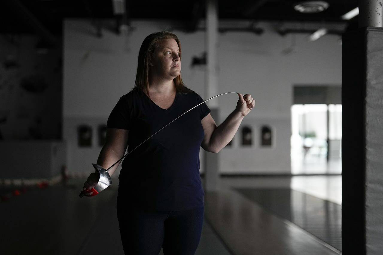 Fencer Kirsten Hawkes poses for a portrait at a fencing studio Tuesday, Sept. 12, 2023, in San Diego. The former elite fencer feels let down by the U.S. Center for SafeSport after filing a complaint to the agency formed six years ago to combat sexual misconduct in Olympic sports. Hawkes’ former coach, who she accused of forcing an unwanted kiss on her and other abuse, never went on a list of the agency’s disciplinary database — not after SafeSport handed him a three-month probation, nor after the probation was overturned by an arbitrator. (AP Photo/Gregory Bull)