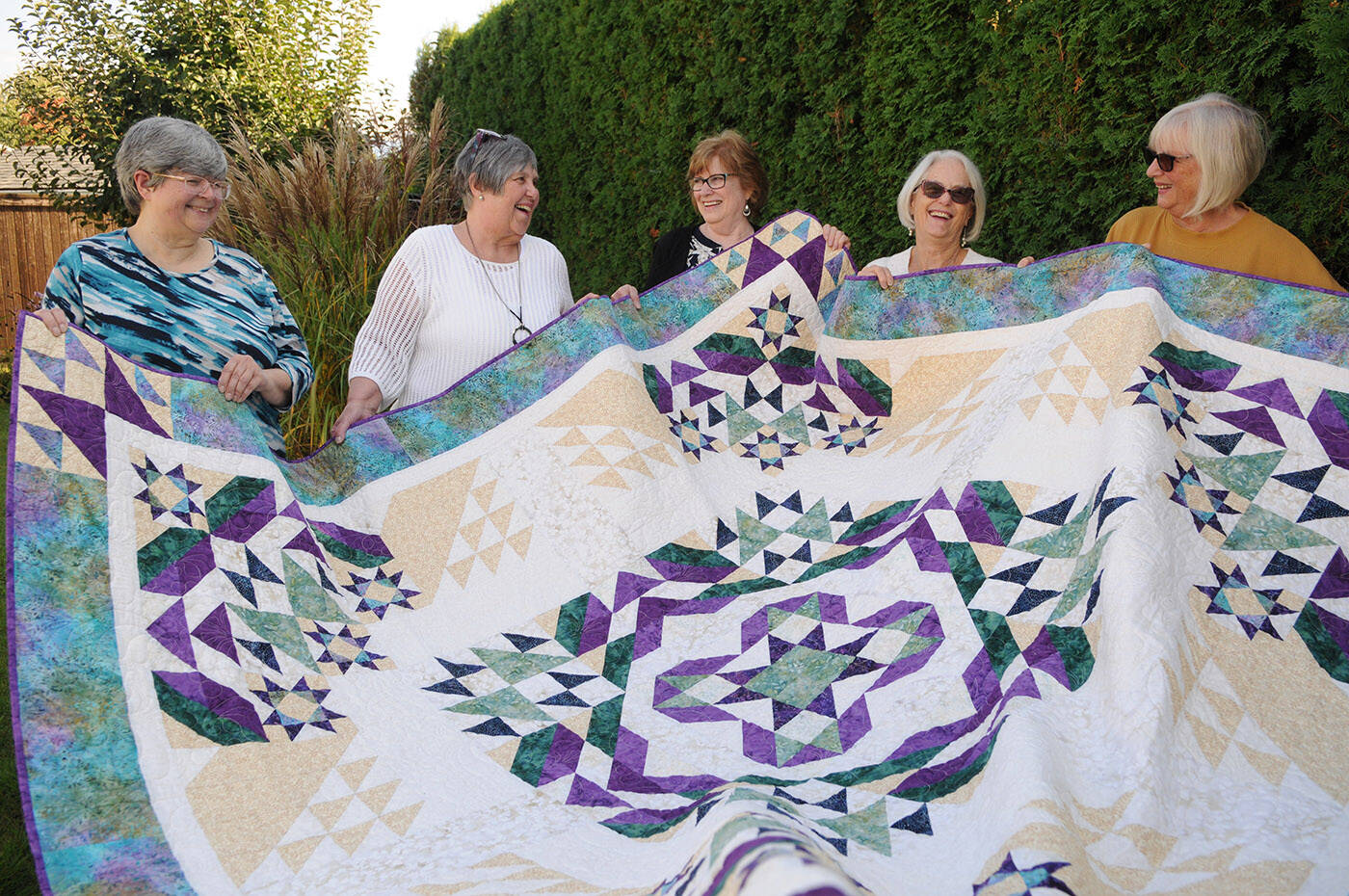 Chilliwack Quilters’ Guild members (from left) Hanne Gidora, Donna Hilton, Darlene Campbell, Shirley Square-Briggs and Kathy Lang hold the quilt that will be raffled off during their biannual show ‘Sew’d to Joy’ which runs Oct. 13 and 14. (Jenna Hauck/ Chilliwack Progress)