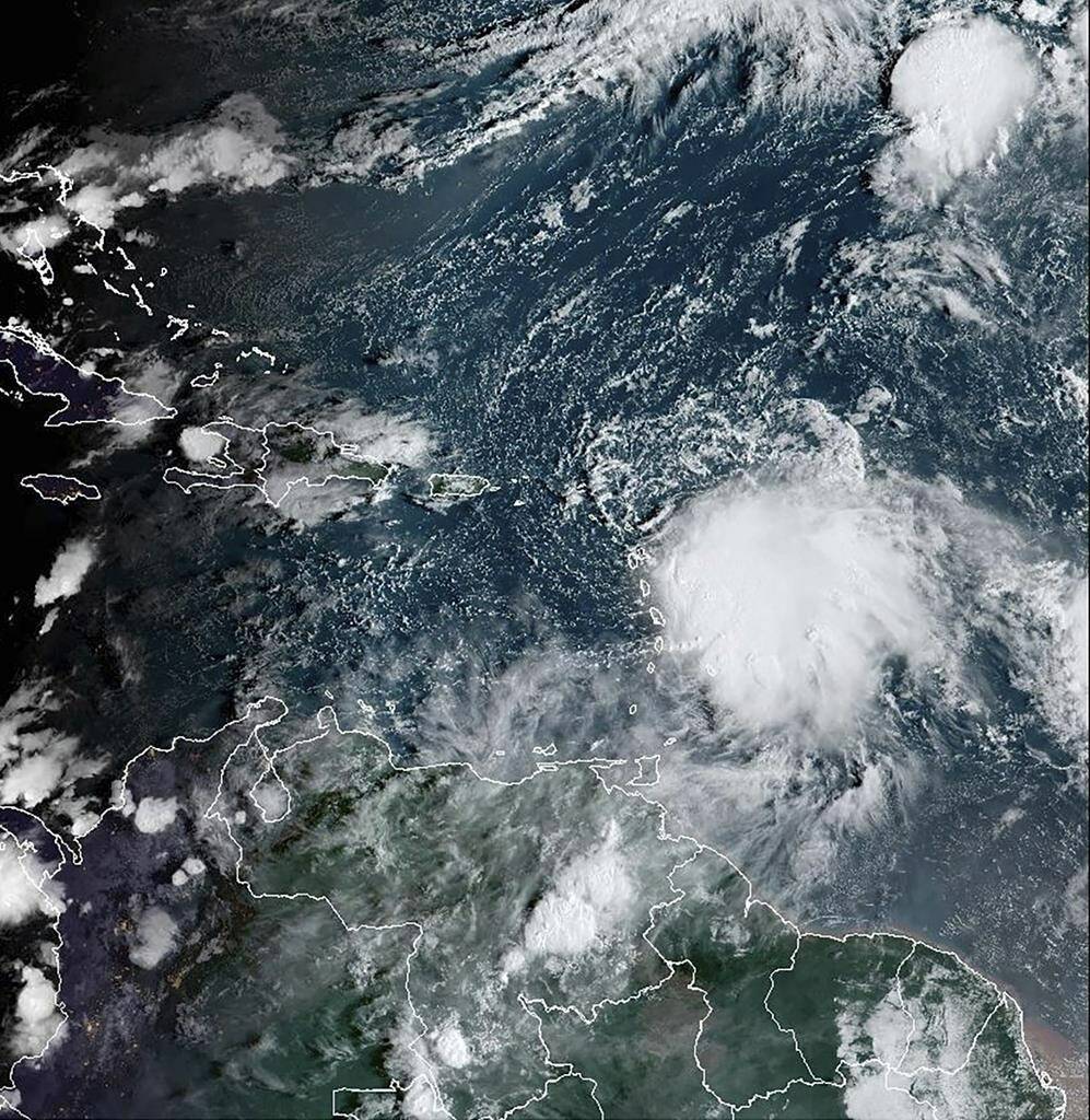 This satellite image provided by NOAA on Monday, Oct. 2 2023 shows Tropical Storm Philippe, center right. Philippe is threatening to unleash heavy rains and flash flooding in the Leeward Islands on Monday before eventually recurving out into the central Atlantic where it could gain hurricane status around midweek, forecasters say. (NOAA via AP)