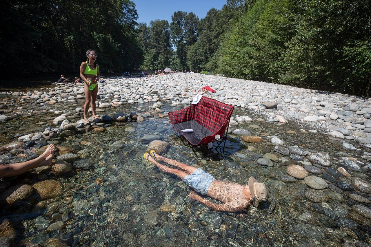 Environment Canada forecasts are calling for near-record temperatures in British Columbia this Thanksgiving weekend, with highs up to 10 degrees above normal in many areas of the northeast, the central and southern Interior, Kootenay, Okanagan and south coast. Albert Huynh cools off in the frigid Lynn Creek water as Leanne Opuyes, left, laughs in North Vancouver, B.C., on Monday, June 28, 2021. THE CANADIAN PRESS/Darryl Dyck