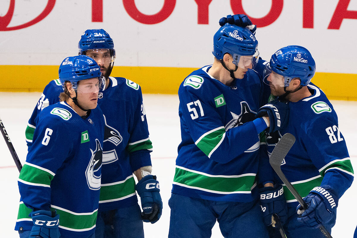 Vancouver Canucks’ Brock Boeser (6), Phillip Di Giuseppe (34), Tyler Myers (57) and Ian Cole (82) celebrate Myers’ goal during the first period of an NHL preseason hockey game in Vancouver on Friday, October 6, 2023. THE CANADIAN PRESS/Ethan Cairns