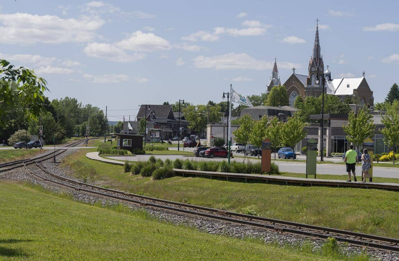 Transport Minister Pablo Rodriguez says preliminary work will begin on the long awaited Lac-Mégantic rail bypass. People walk on the boardwalk built along the crash site of a train derailment in Lac-Mégantic, Que., on Thursday, June 22, 2023. THE CANADIAN PRESS/Christinne Muschi
