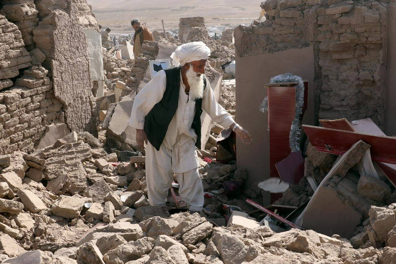 A man searches through rubble after an earthquake in Zenda Jan district in Herat province, of western Afghanistan, Sunday, Oct. 8, 2023.The federal Minister of Foreign Affairs is offering support to people in Afghanistan after a devastating earthquake rocked the western part of the Asian country on Saturday. THE CANADIAN PRESS/AP/Omid Haqjoo