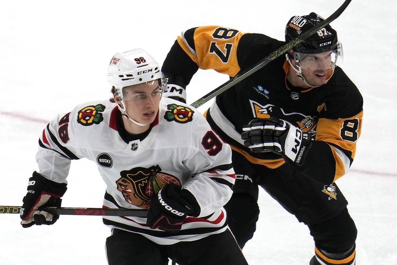 Chicago Blackhawks’ Connor Bedard (98) and Pittsburgh Penguins’ Sidney Crosby (87) skate during the second period of an NHL hockey game in Pittsburgh, Tuesday, Oct. 10, 2023. (AP Photo/Gene J. Puskar)