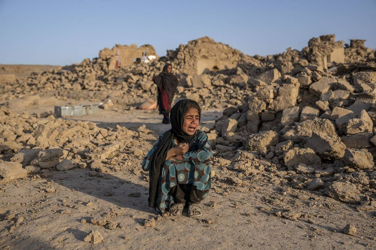An Afghan girl cries in front of her house that was destroyed by the earthquake in Zenda Jan district in Herat province, western Afghanistan, Wednesday, Oct. 11, 2023. Another strong earthquake shook western Afghanistan on Wednesday morning after an earlier one killed more than 2,000 people and flattened whole villages in Herat province in what was one of the most destructive quakes in the country’s recent history. (AP Photo/Ebrahim Noroozi)