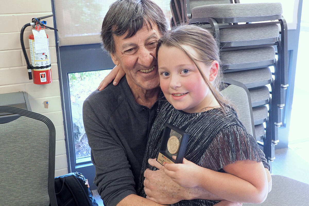 Bernard Biro and granddaughter Lucia Elizabeth Dell share a moment Wednesday, Oct. 11, after Dell became the youngest person ever to receive the B.C. Emergency Health Services Vital Link Award for her role in saving Biro’s life. (Chris Bush/News Bulletin)