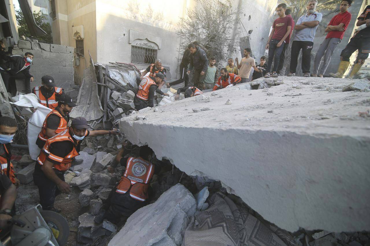 Palestinians search for survivors in the building of the Zanon family, destroyed in Israeli airstrikes in Rafah, Gaza Strip, Saturday, Oct. 14, 2023. (AP Photo/Hatem Ali)