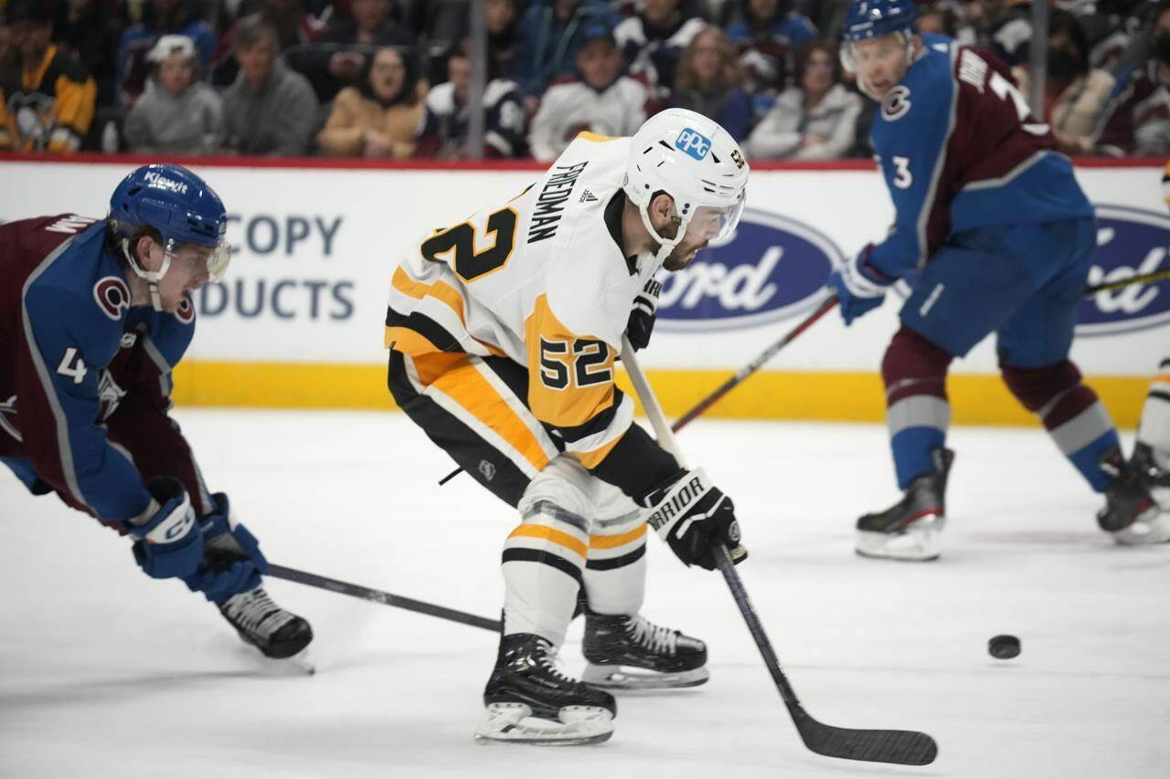 Pittsburgh Penguins defenceman Mark Friedman, right, fields the puck after driving past Colorado Avalanche defenseman Bowen Byram in the second period of an NHL hockey game Wednesday, March 22, 2023, in Denver. The Vancouver Canucks have acquired Friedman and forward Ty Glover from the Penguins. THE CANADIAN PRESS/AP-David Zalubowski