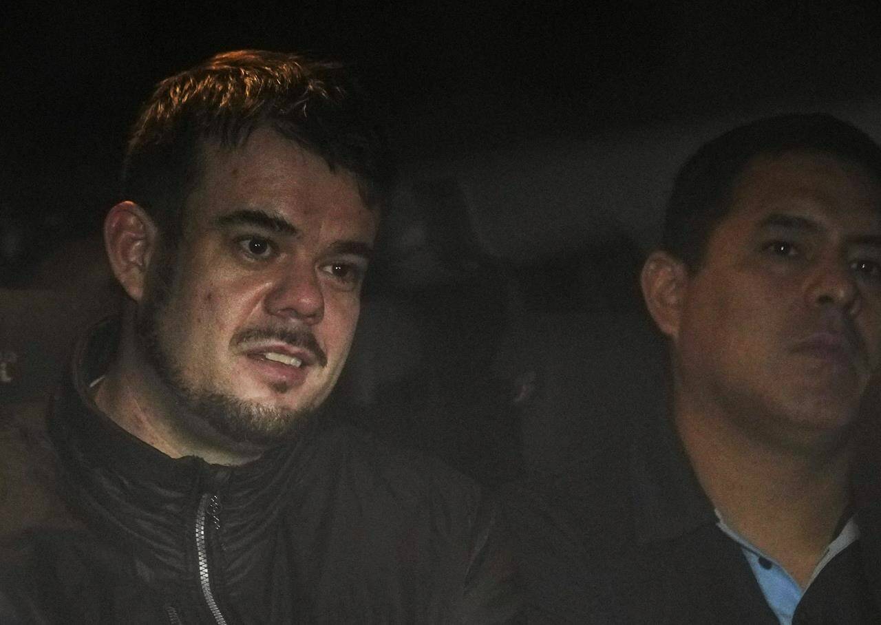 FILE - Dutch citizen Joran van der Sloot, left, is driven in a police vehicle from a maximum-security prison to an airport to be extradited to the U.S., on the outskirts of Lima, Peru, Thursday, June 8, 2023. Court records filed Friday, Oct. 13, indicate Van der Sloot, the chief suspect in Natalee Holloway’s 2005 disappearance, intends to plead guilty in a federal case accusing him of trying to extort money from the missing teen’s mother. (AP Photo/Martin Mejia, File)