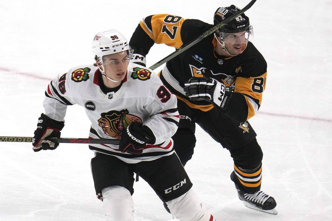 Chicago Blackhawks’ Connor Bedard (98) and Pittsburgh Penguins’ Sidney Crosby (87) skate during the second period of an NHL hockey game in Pittsburgh, Tuesday, Oct. 10, 2023. THE CANADIAN PRESS/AP/Gene J. Puskar