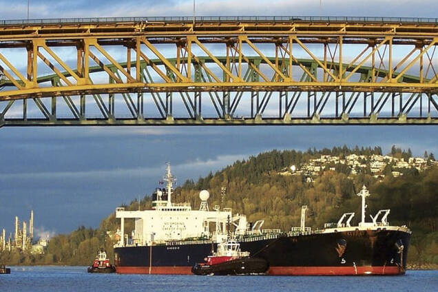 A partially loaded crude oil tanker is guided out of Burrard Inlet from Burnaby’s Westridge Terminal next to the Chevron oil refinery. (File - Black Press Media)