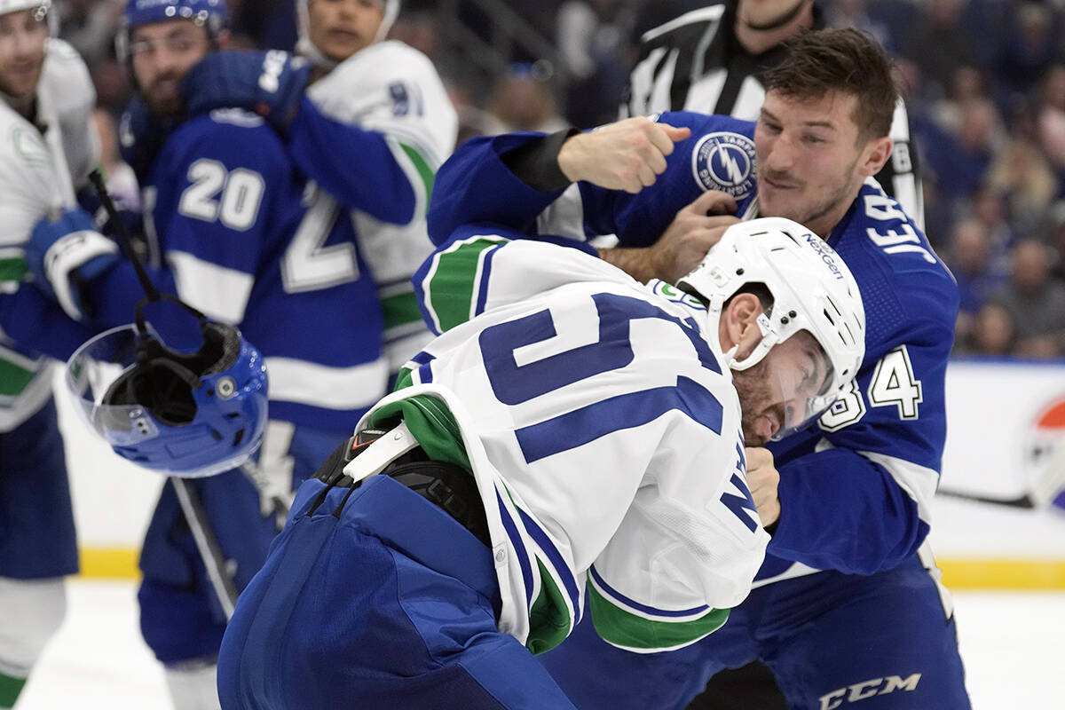 Vancouver Canucks Mark Friedman and Tampa Bay Lightning left wing Tanner Jeannot (84) fight during the second period of an NHL hockey game Thursday, Oct. 19, 2023, in Tampa, Fla. (AP Photo/Chris O’Meara)