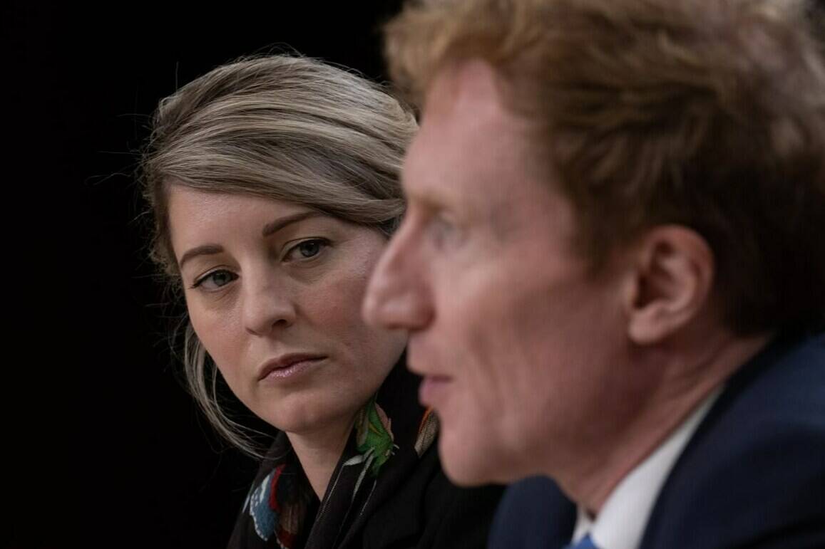Minister of Foreign Affairs Melanie Joly listens to Immigration, Refugees and Citizenship Minister Marc Miller speak during a news conference, Thursday, October 19, 2023 in Ottawa. Joly says Canada has removed most of its diplomatic presence from India after New Delhi threatened to strip diplomatic immunities from them and their families. THE CANADIAN PRESS/Adrian Wyld