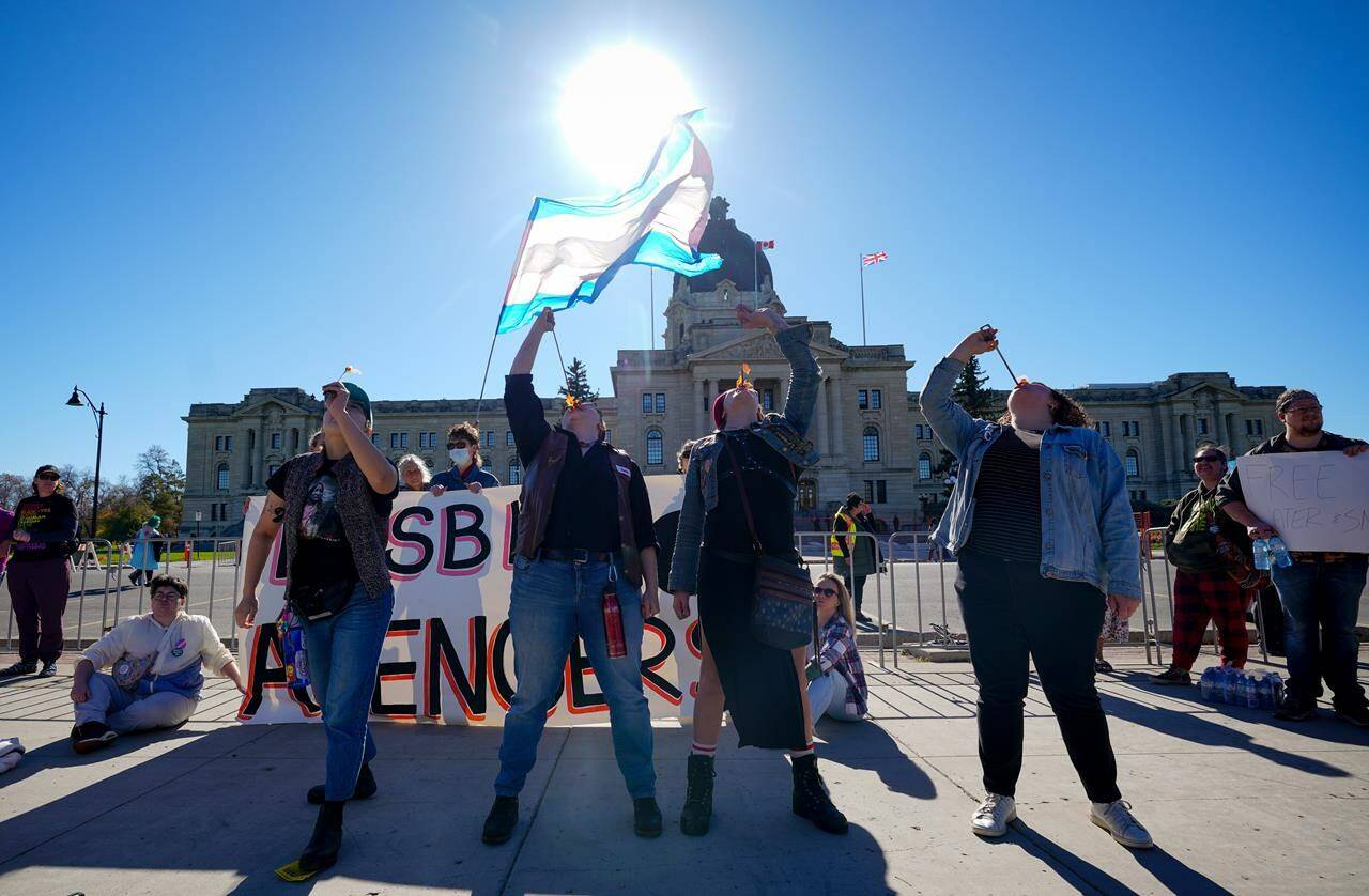 People attend a rally opposing the Saskatchewan government’s proposed legislation on pronoun policy in front of the Saskatchewan Legislature in Regina, Tuesday, Oct. 10, 2023. Saskatchewan politicians are to return to the legislature today for third reading on the government’s proposed pronoun bill. THE CANADIAN PRESS/Heywood Yu