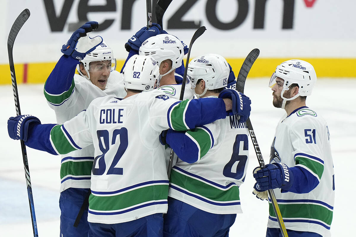Teammates congratulate Vancouver Canucks centre Elias Pettersson, middle, after he scored during the second period of an NHL hockey game against the Florida Panthers, Saturday, Oct. 21, 2023, in Sunrise, Fla. (AP Photo/Wilfredo Lee)