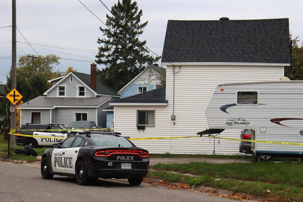 Police tape and vehicles surround a crime scene in Sault Ste. Marie, Ont. on Tuesday, Oct.24, 2023. Five people - including three children and a shooter - were found dead in the northern Ontario city after shootings at two homes, police said Tuesday, calling what happened a tragic case of intimate partner violence. THE CANADIAN PRESS/HO-Soo Today-Alex Flood
