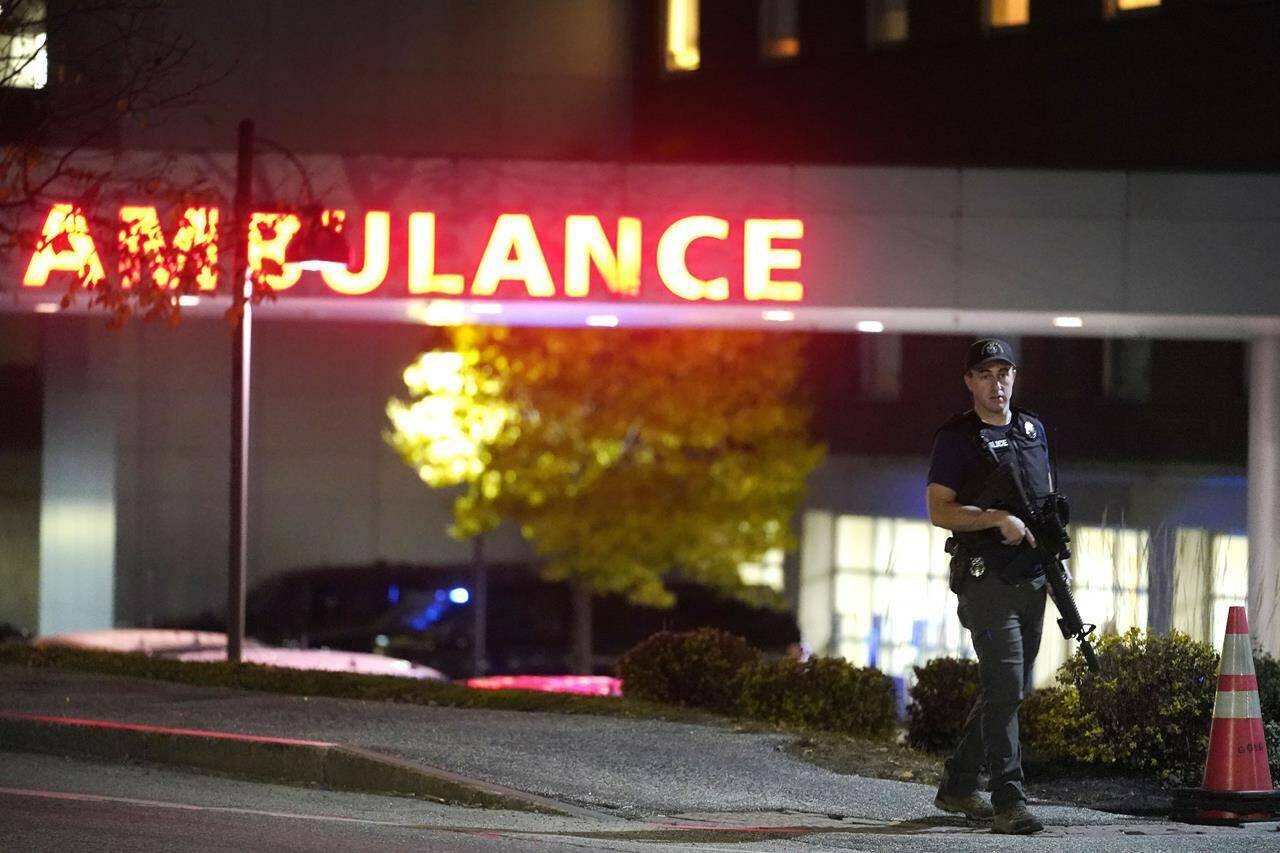 A law enforcement officer carries a rifle outside Central Maine Medical Center during an active shooter situation, in Lewiston, Maine, Wednesday, Oct. 25, 2023. (AP Photo/Steven Senne)