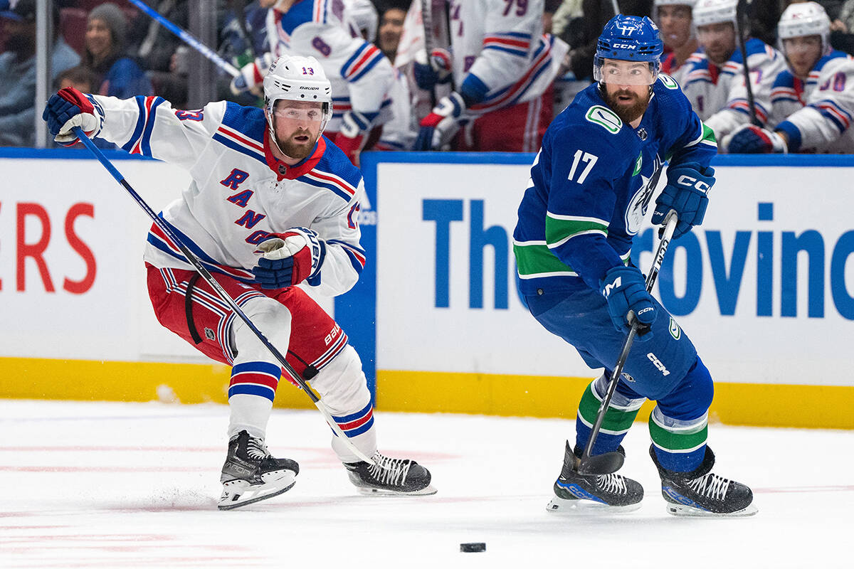 New York Rangers’ Alexis Lafreniere (13) skates after Vancouver Canucks’ Filip Hronek (17) during the first period of an NHL hockey game in Vancouver, on Saturday, Oct. 28, 2023. THE CANADIAN PRESS/Ethan Cairns