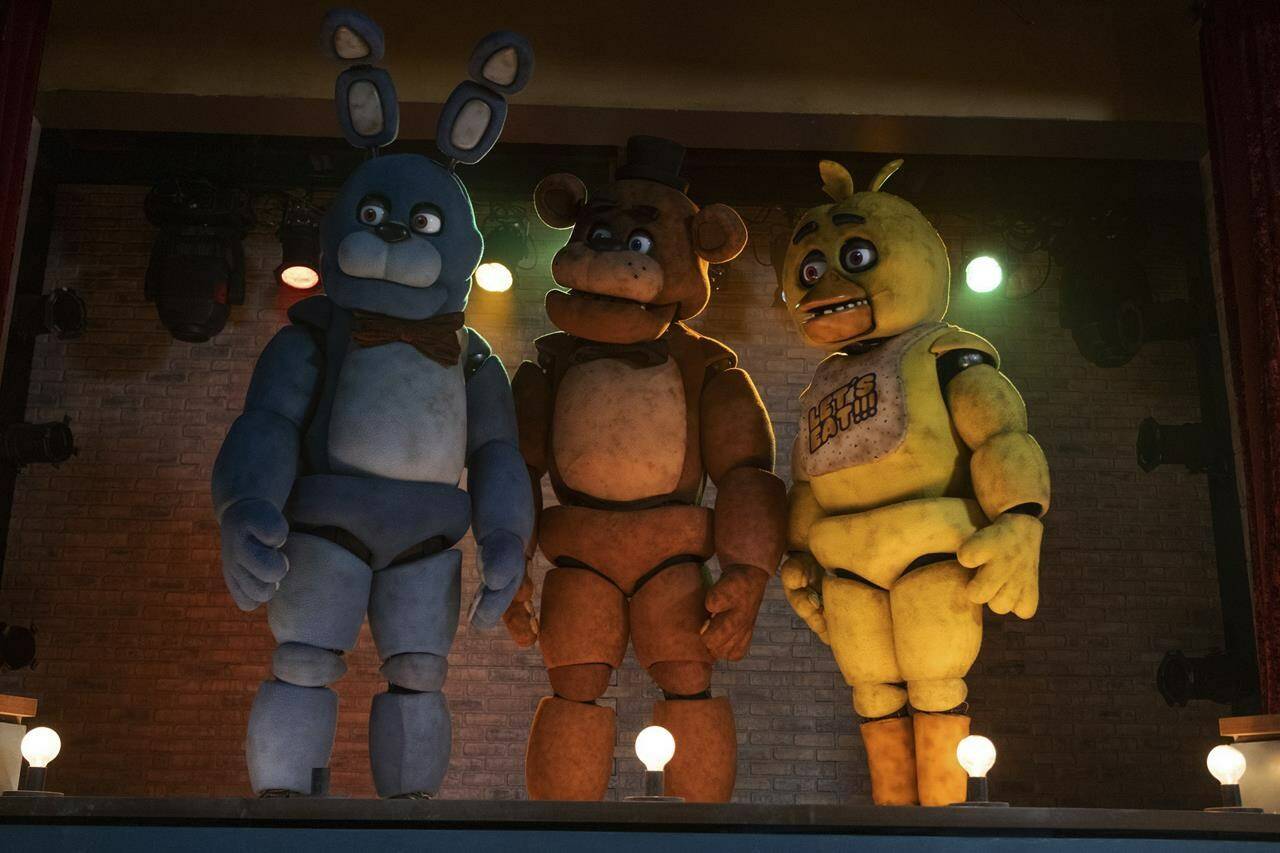 This image released by Universal Pictures shows, from left, Bonnie, Freddy Fazbear and Chica in a scene from “Five Nights at Freddy’s.” (Universal Pictures via AP)
