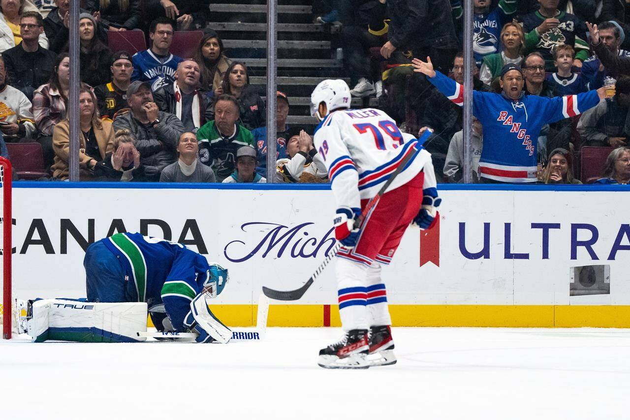 Vancouver Canucks goaltender Casey DeSmith (29) reacts as New York Rangers’ K’Andre Miller (79) celebrates his goal during overtime of an NHL hockey game in Vancouver, on Saturday, Oct. 28, 2023. THE CANADIAN PRESS/Ethan Cairns
