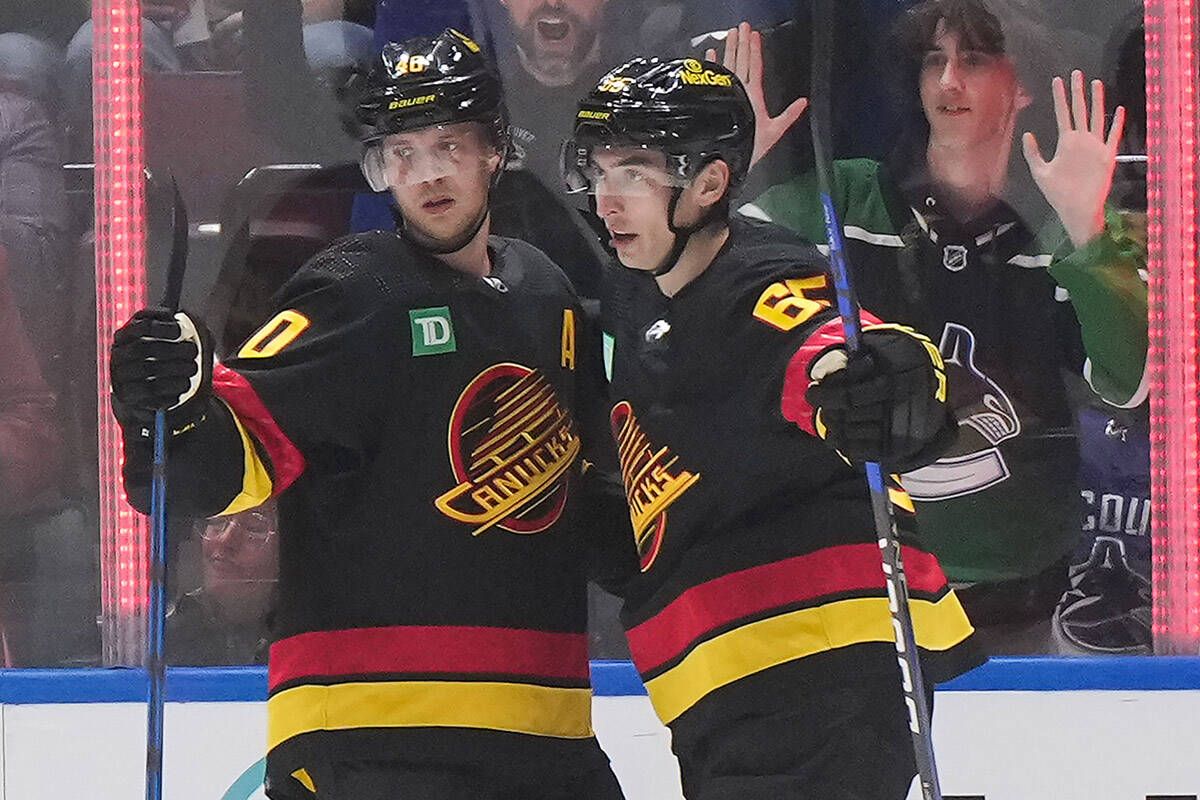 Vancouver Canucks’ Quinn Hughes, from left to right, Elias Pettersson and Ilya Mikheyev celebrate Pettersson’s first goal against the Nashville Predators during the second period of an NHL hockey game, in Vancouver, on Tuesday, October 31, 2023. THE CANADIAN PRESS/Darryl Dyck