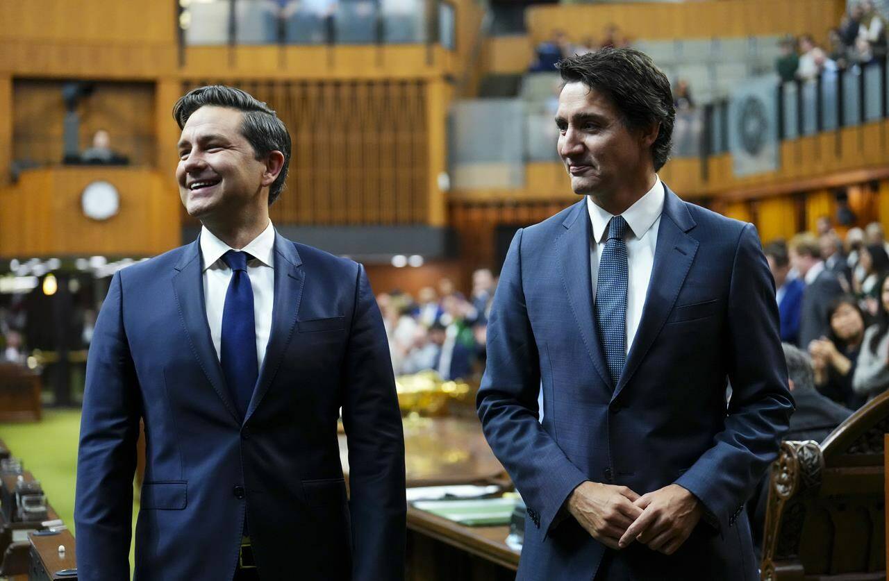 Prime Minister Justin Trudeau and Conservative Leader Pierre Poilievre wait to continue escorting Newly elected Speaker of the House of Commons Greg Fergus to his seat on Parliament Hill in Ottawa on Tuesday, Oct. 3, 2023. The Conservative party is maintaining a steady lead over Prime Minister Justin Trudeau’s Liberals, a new poll suggests, at a time when Canadians are reporting limited trust in their institutions.THE CANADIAN PRESS/Sean Kilpatrick