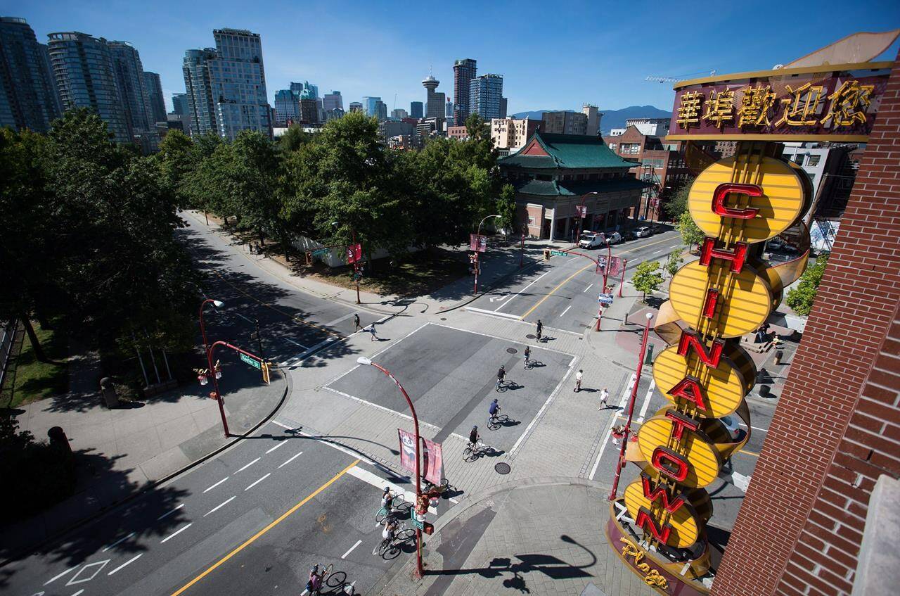 Cyclists ride past a neon Chinatown sign in Vancouver, B.C., on Thursday Aug. 18, 2016. A man accused of stabbing three people lost his bid to seal a document that identified him as a "significant threat" before he was release from a forensic psychiatric hospital. THE CANADIAN PRESS/Darryl Dyck