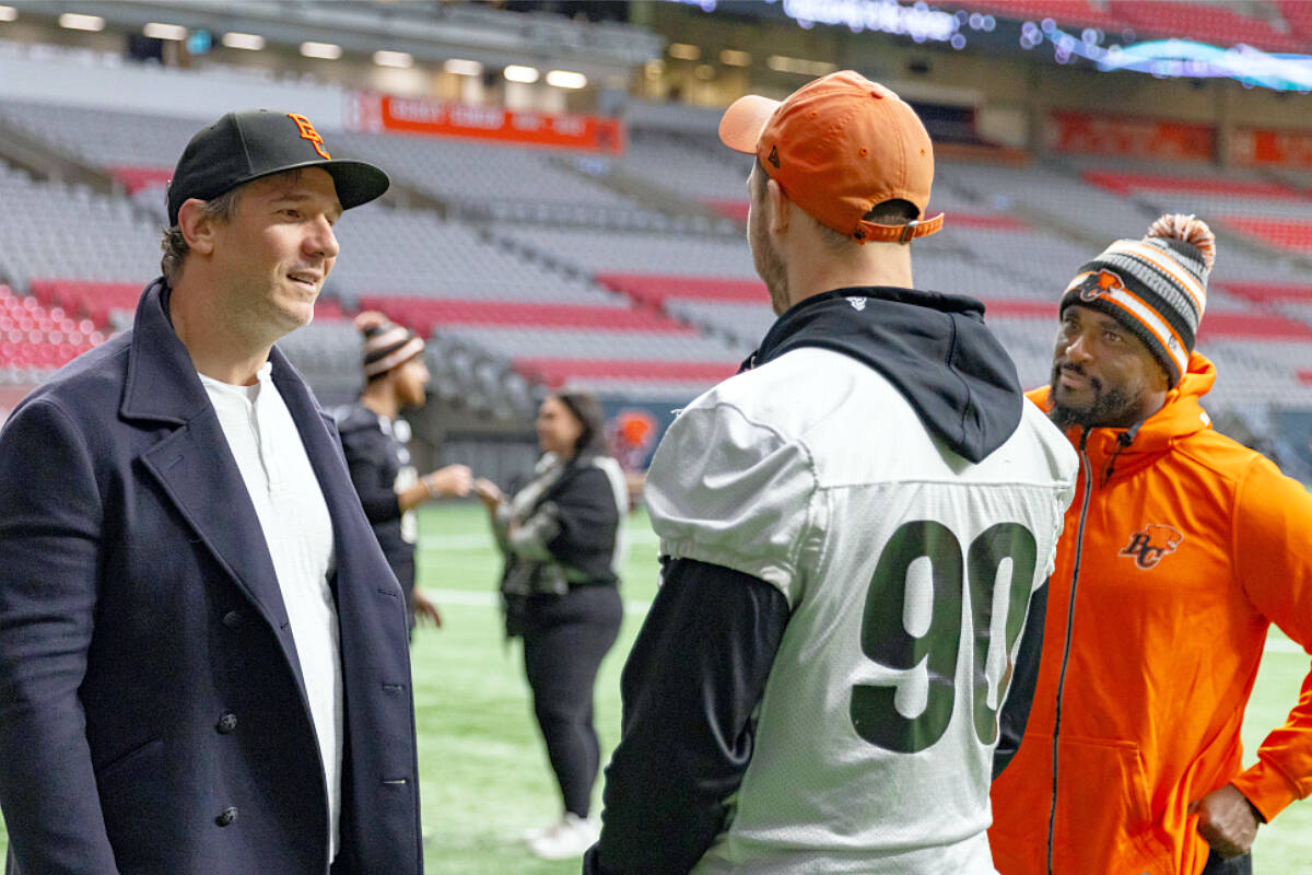 SACK KINGS: CFL Hall of Famer and former B.C. Lion Brent Johnson chats with current Lion Mathieu Betts while defensive coordinator Ryan Phillips looks on. Betts' 18 quarterback sacks this year broke Johnson's record (17) for sacks by a Canadian in a single season. (Steven Chang B.C. Lions photo)