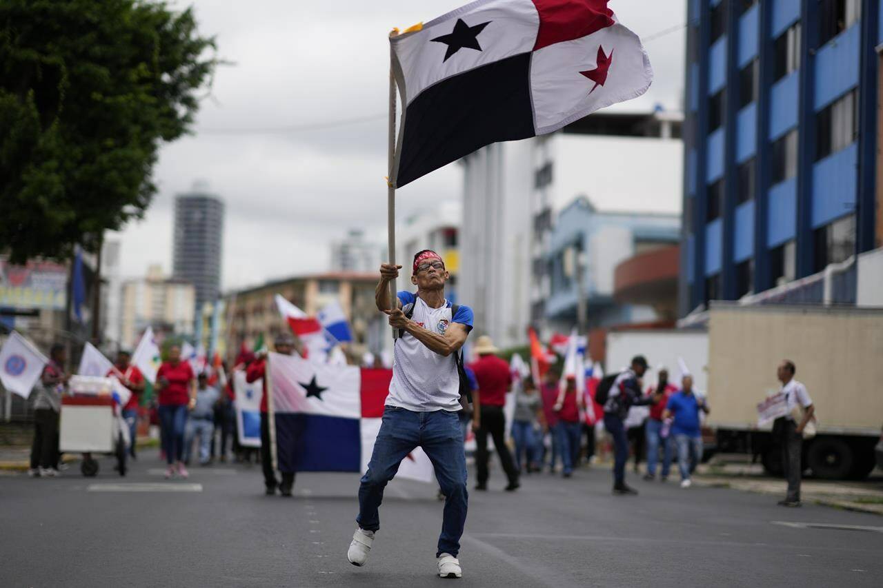 A demonstrator waves a Panamanian national flag during a protest against a mining contract between the Panamanian government and the Canadian mining company First Quantum, in Panama City, Friday, Nov. 3, 2023. (AP Photo/Arnulfo Franco)