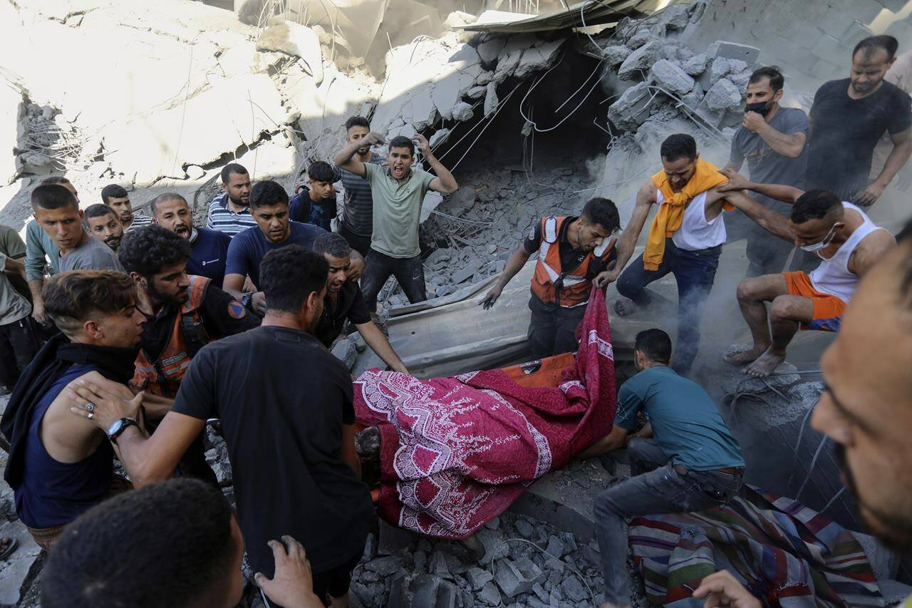 Palestinians carry a dead person from under the rubble of a destroyed house following an Israeli airstrike in Gaza City, Saturday, Nov. 4, 2023. (AP Photo/Abed Khaled)