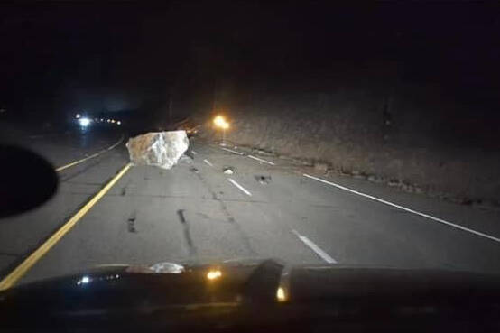 A large boulder can be seen on Highway 3 west of Keremeos on Sunday night. The highway is closed until at least Monday afternoon. (Christopher Erb photo)