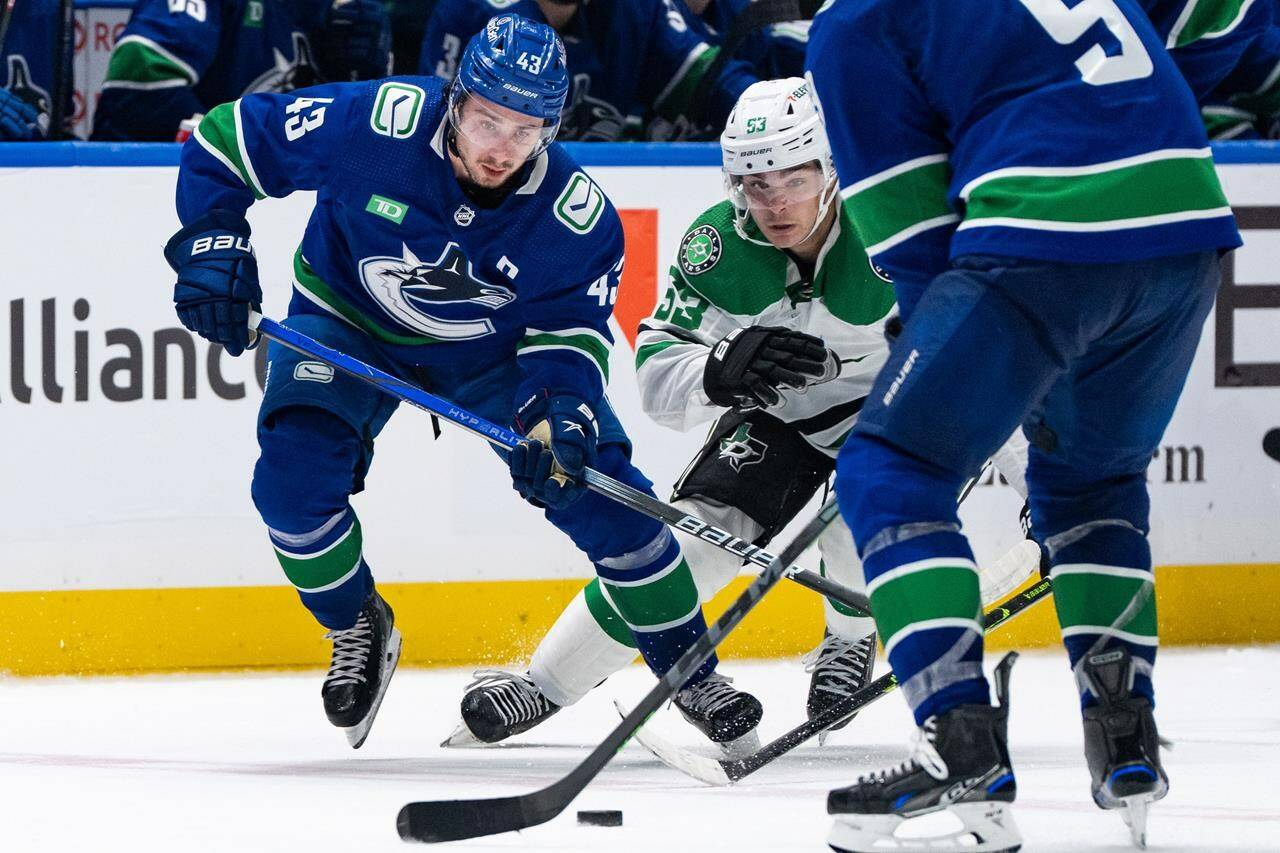 Vancouver Canucks’ Quinn Hughes (43) and Dallas Stars’ Wyatt Johnston (53) vie for the puck during the second period of an NHL hockey game in Vancouver, on Saturday, Nov. 4, 2023. Hughes has been named the NHL’s first star of the week after putting up eight points over his last three games. THE CANADIAN PRESS/Ethan Cairns