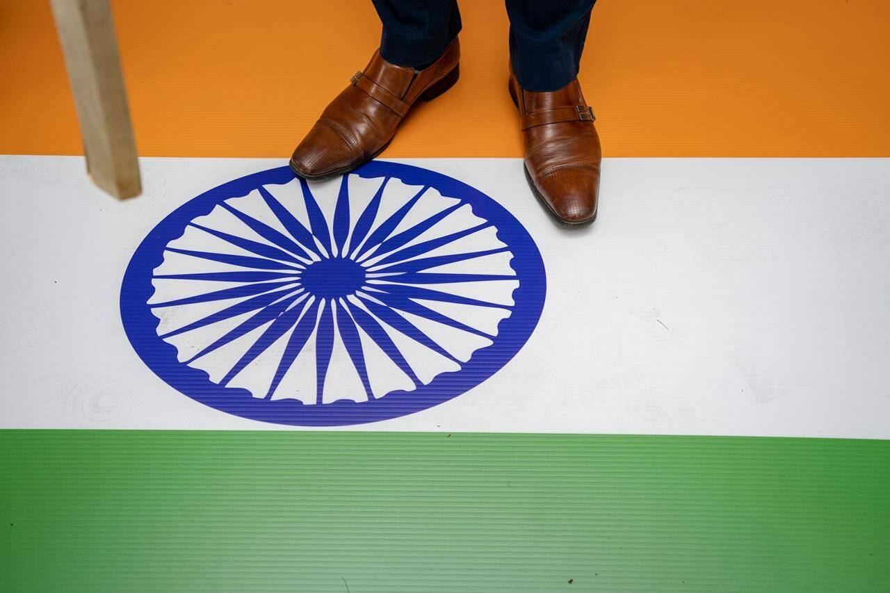 A protester stands on the Indian flag outside of the Consulate General of India office during a protest in Vancouver on Saturday, June 24, 2023. Business leaders continue to fret over the economic uncertainty fostered by the rift between the Canadian and Indian governments, saying the ongoing suspension of free trade talks hurts both sides. THE CANADIAN PRESS/Ethan Cairns
