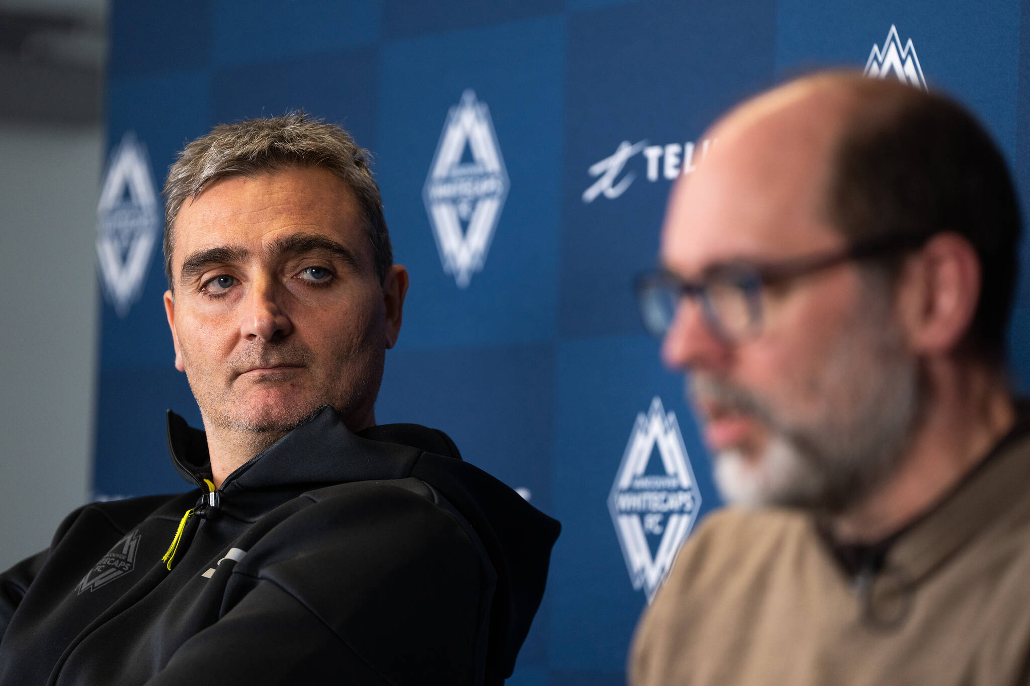 Vancouver Whitecaps FC head coach Vanni Sartini, left, looks on as CEO & Sporting Director Axel Schuster speaks during an end-of-season news conference in Vancouver, on Tuesday, Nov. 7, 2023. THE CANADIAN PRESS/Ethan Cairns