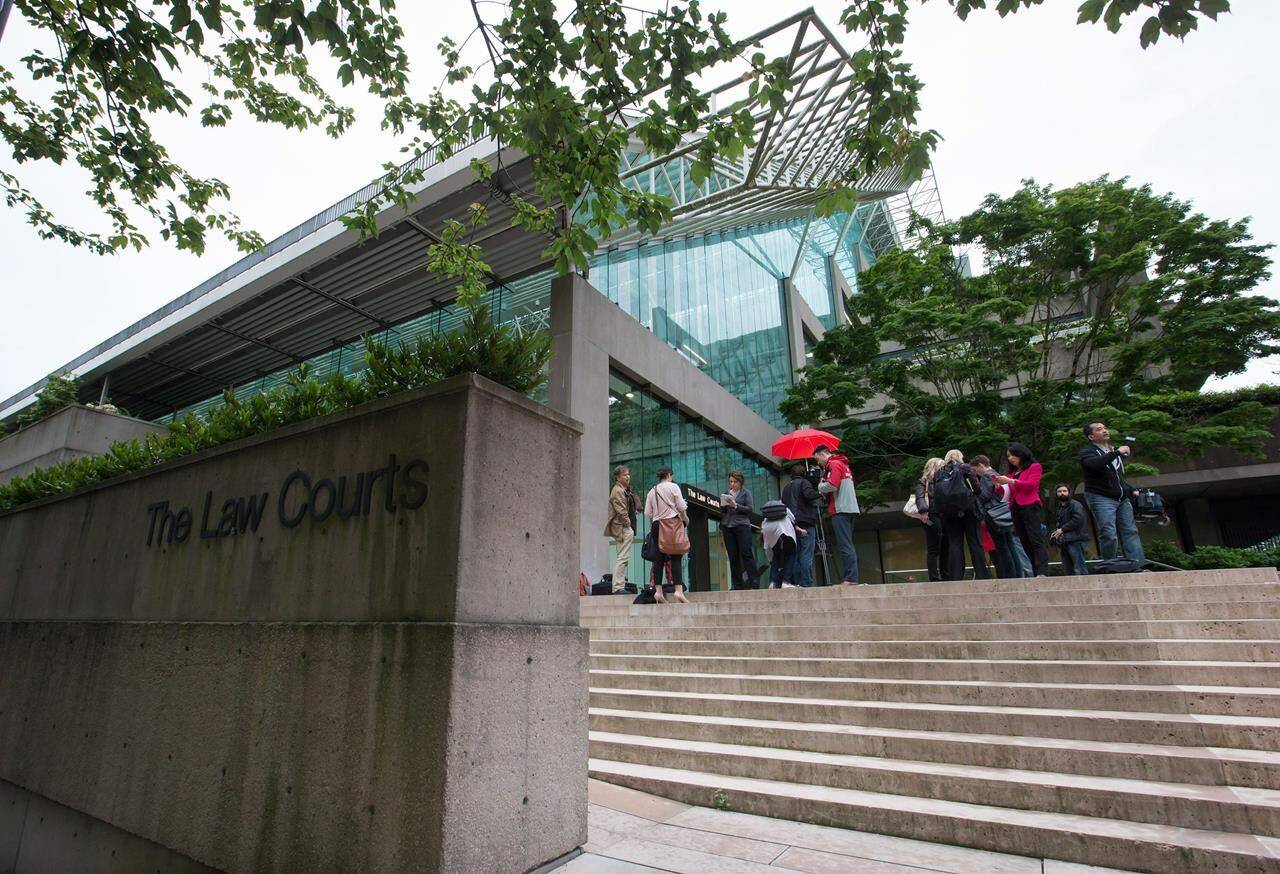 The judge in the first-degree murder trial of Ibrahim Ali, who is accused of killing a Burnaby, B.C., teenager six years ago, has told the jury to completely disregard the testimony of a witness who died before the end of her cross-examination. Media wait outside B.C. Supreme Court, in Vancouver, B.C., on Tuesday, June 2, 2015. THE CANADIAN PRESS/Darryl Dyck