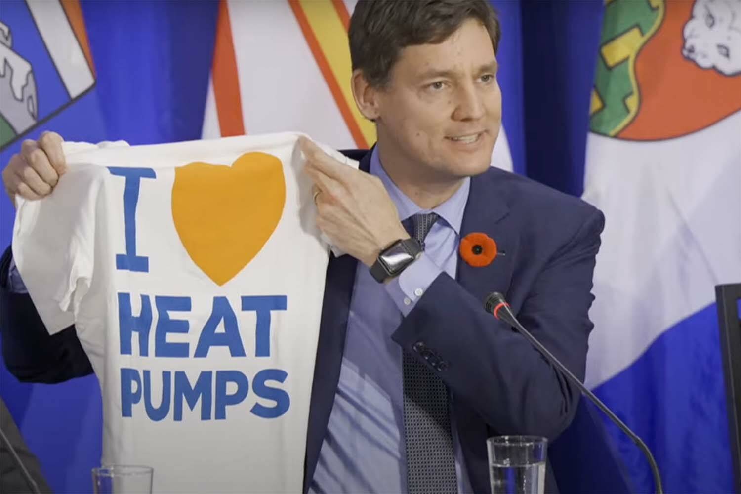 Premier David Eby, seen here in Nova Scotia, warns against playing affordability off against climate change. During a meeting with federal and territorial leaders in Nova Scotia he held up an “I Heart Heat Pumps” T-shirt during interviews. (Screencap)