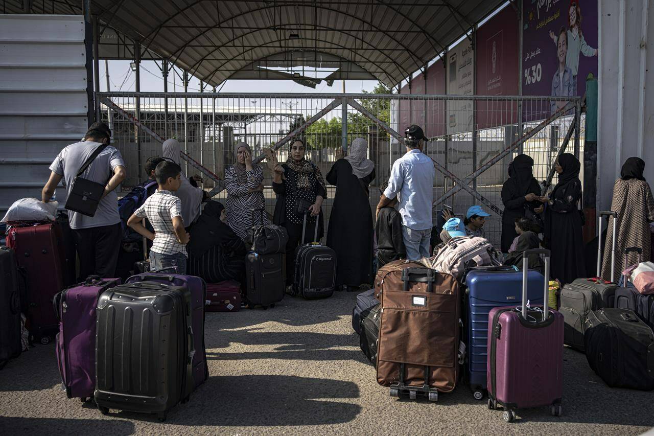 Palestinians wait to cross into Egypt at Rafah, Gaza Strip, on Wednesday, Nov. 1, 2023. THE CANADIAN PRESS/AP/Fatima Shbair