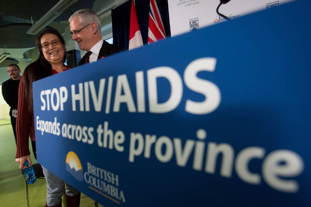 In this 2012 file photo the then director of the B.C. Centre for Excellence in HIV/AIDS, Dr. Julio Montaner, speaks with a patient about new annual funding to combat HIV/AIDS. In 2023, advocates continue to call for B.C. to improve access to an injectable HIV drug. (THE CANADIAN PRESS/Darryl Dyck)