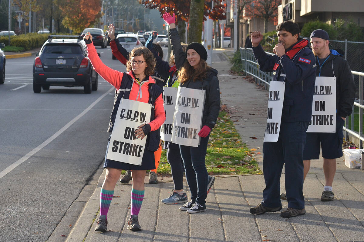 Canada Post employees on strike in South Surrey in 2018. A new federal bill will ban industries from replacing workers during strikes. (Black Press Media file photo)