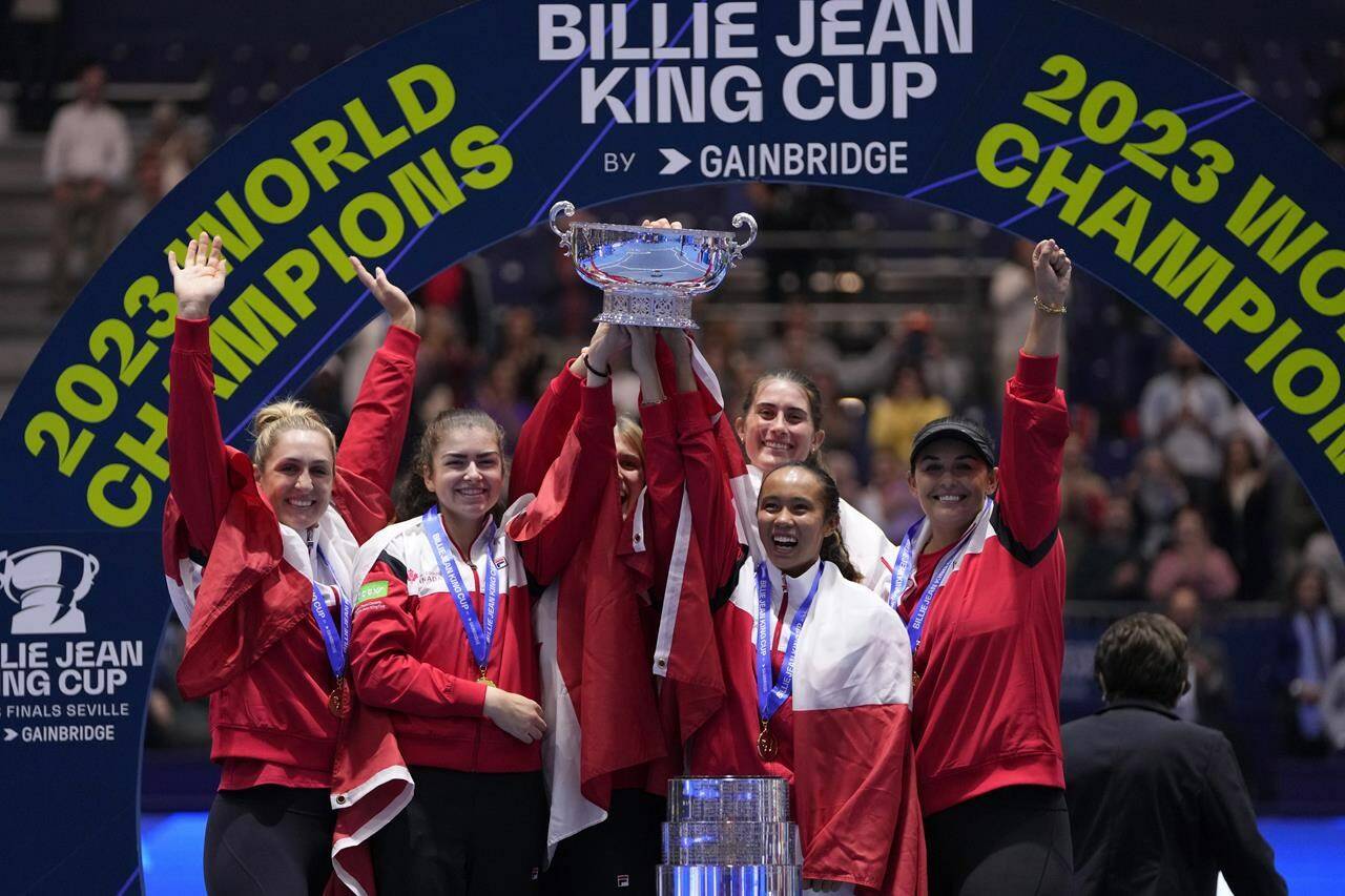 Canada’s Leylah Fernandez, right, lifts the trophy with members of her team after wining the final singles tennis match against Italy’s Jasmine Paolini, during the Billie Jean King Cup finals in La Cartuja stadium in Seville, southern Spain, Spain, Sunday, Nov. 12, 2023. THE CANADIAN PRESS/AP-Manu Fernandez