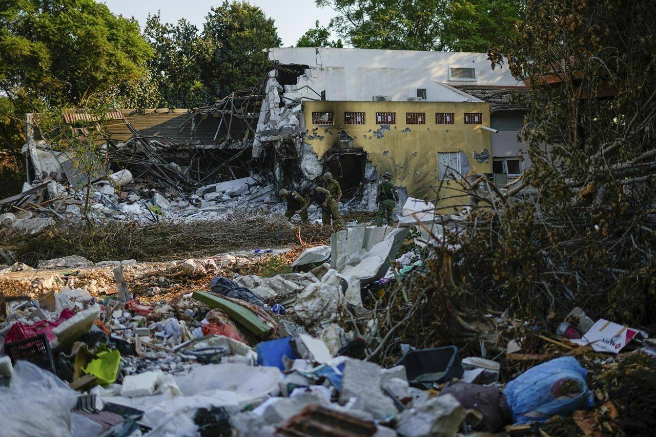 Israeli soldiers walk past houses destroyed by Hamas militants in Kibbutz Be’eri, Israel, Saturday, Oct. 14, 2023. Israel’s consul general in Toronto says Canadian-Israeli peace activist Vivian Silver has been found dead. She was previously believed to be taken hostage in the Hamas attack on her community near the Gaza Strip on Oct. 7. THE CANADIAN PRESS/AP, Ariel Schalit